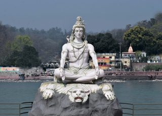 a statue of a person sitting on top of a rock