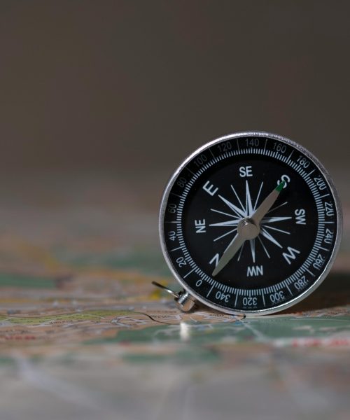 A detailed image of a compass on a map, symbolizing navigation and exploration.