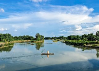 A body of water surrounded by lush green trees